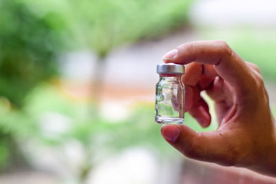 Close-up of person holding glass bottle