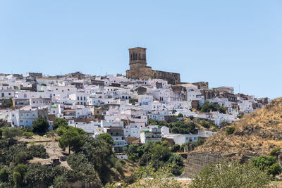 Buildings in town against clear sky