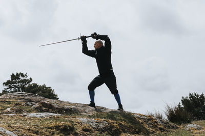 Low angle view of man standing on rock