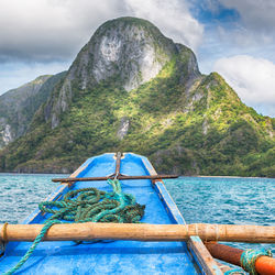 Scenic view of sea by mountains against sky