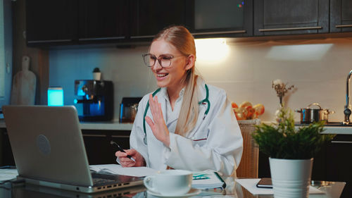 Mid adult woman using laptop on table