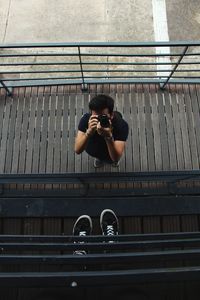 High angle view of man photographing while standing on footbridge