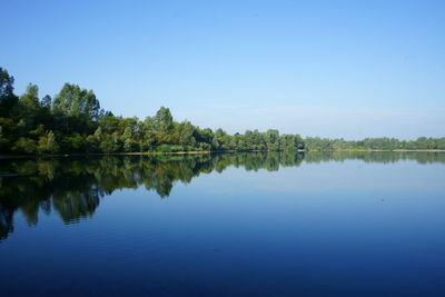 Scenic view of lake against clear blue sky