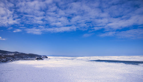 Scenic view of snowcapped landscape against blue sky