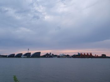 View of sea and buildings against sky during sunset