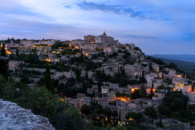 High angle view of illuminated buildings in town against sky