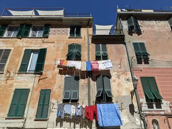 Low angle view of old, multi-storey residential building with hanging clothesline in italy.