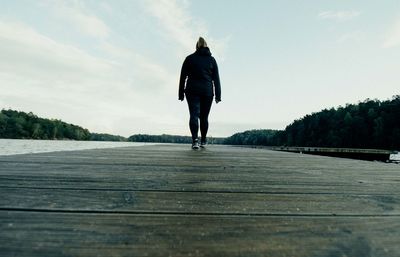 Rear view of a man walking on road