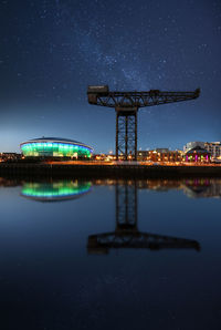 Illuminated built structure against sky at night