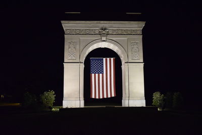 American flag suspended under historic arch 