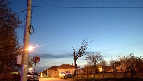 Illuminated cars against sky at night