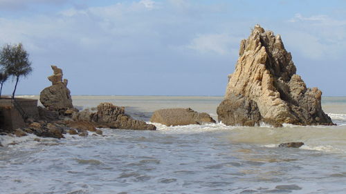 Rocks on beach against sky