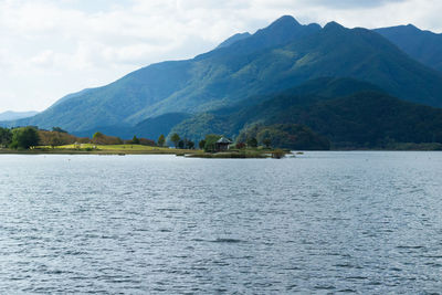 Scenic view of lake by mountains against sky