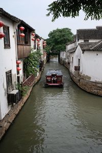 Boats moored in canal against sky