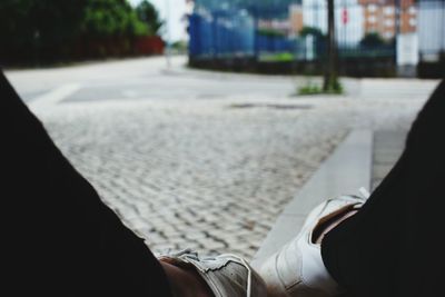 Low section of man on road in city
