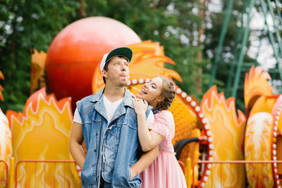 Happy couple in love having fun in an amusement park, eating lollipops person