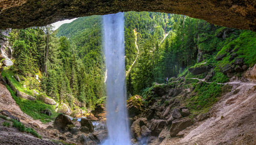Scenic view from  behind waterfall in forest