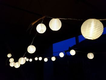 Low angle view of illuminated pendant lights hanging from ceiling