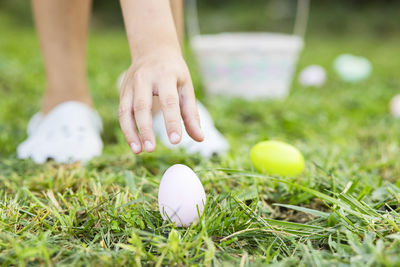 Cropped hand of woman with pills on field