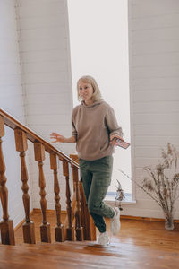 Portrait of young woman standing on staircase