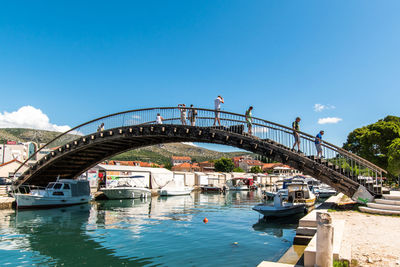 Arch bridge over river against blue sky