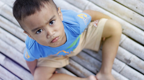 High angle portrait of cute boy sitting on floor