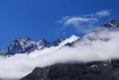 Low angle view of snowcapped mountains against sky