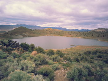 Scenic view of lake against cloudy sky