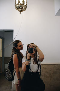 Two woman taking a salfie on the mirror 