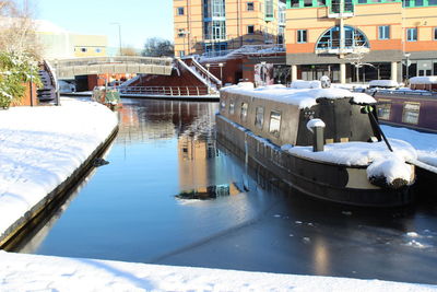Boats moored on snow in city