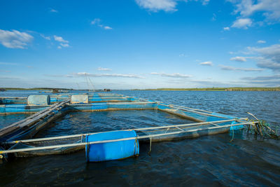 Boat moored on sea against blue sky