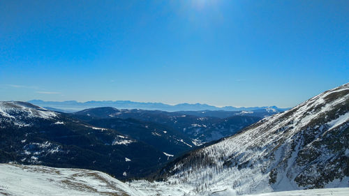 Scenic view of snowcapped mountains against clear blue sky