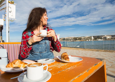 Woman holding coffee cup on table