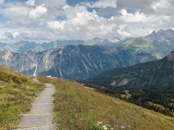 Panoramic view of path amidst mountains against sky