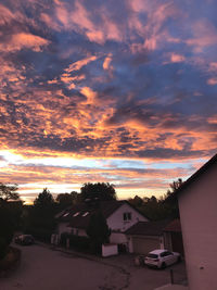 Houses and buildings against sky during sunset