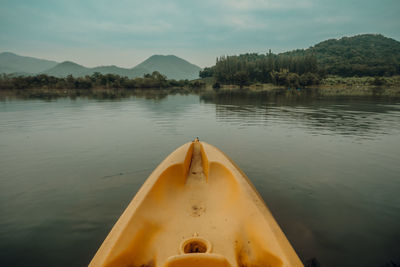 Low section of woman standing by lake against sky