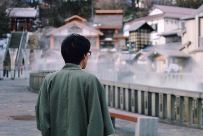 Rear view of woman standing in front of building