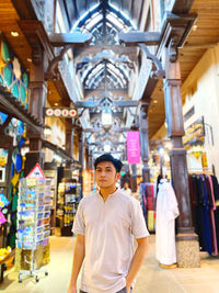 Portrait of young man standing in building