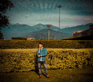 Portrait of man standing on mountain against sky