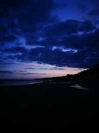 Scenic view of beach against cloudy sky
