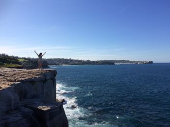 Statue by sea against blue sky