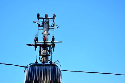 Low angle view of windmill against clear blue sky