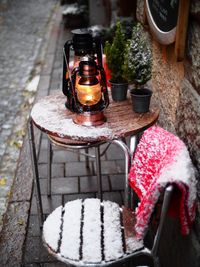 Snow covered table and chair at sidewalk cafe