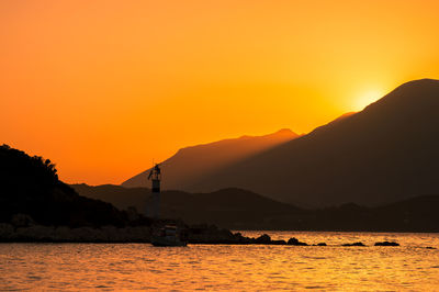 Scenic view of sea and mountains against sky during sunset