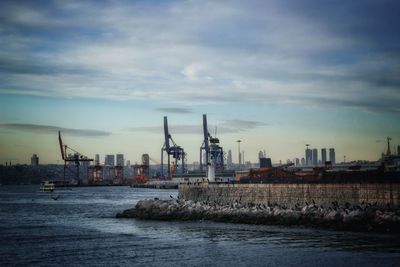 Commercial dock by sea against sky during sunset