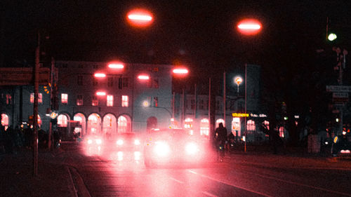 People walking on illuminated road at night