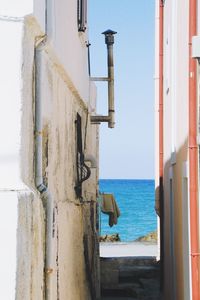 Old wooden post by sea against sky