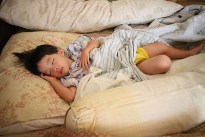High angle view of child sleeping on bed