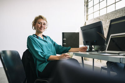 Portrait of smiling woman sitting on chair