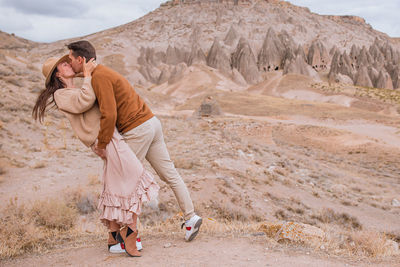 Full length of woman standing on sand at desert